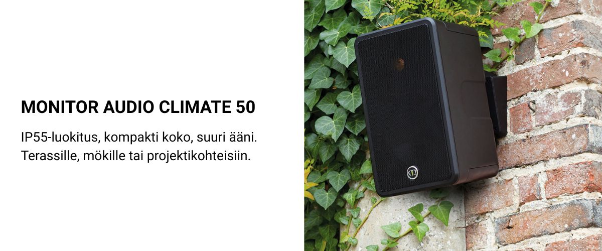 Monitor Audio Climate 50 musta ulkokaiutin asennettuna tiiliseinälle, ympärillä vihreää köynnöskasvillisuutta