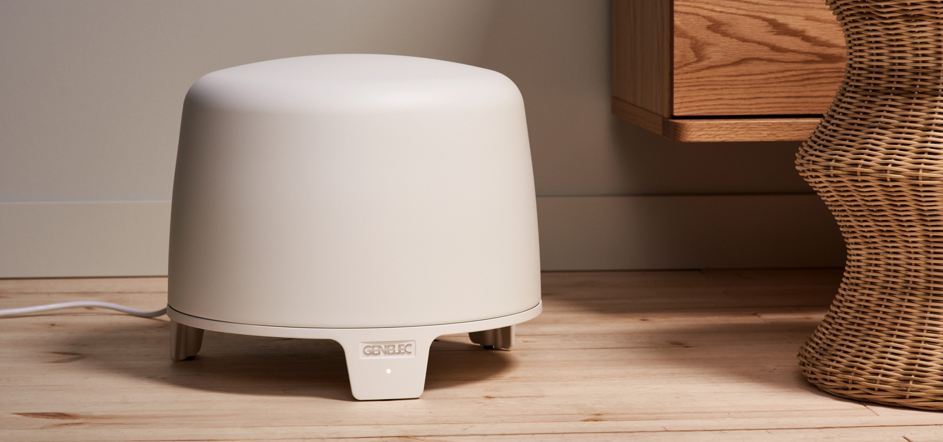 Valkoinen Genelec F-sarjan subwoofer olohuoneen lattialla